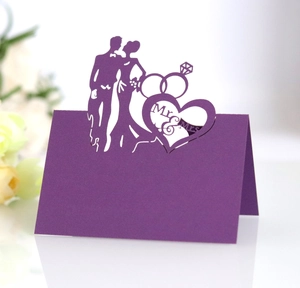 Detail of purple laser-cut wedding place card with Mr & Mrs text and bride groom silhouette
