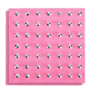 Detail of pink textured ear piercing tool base with silver studs in a neat arrangement