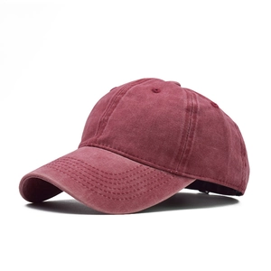 Detail of burgundy washed cotton baseball cap showing vintage texture and side profile