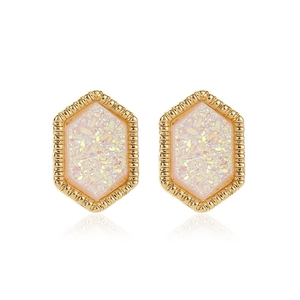Detailed macro view of pink iridescent hexagonal stud earrings with gold textured frames
