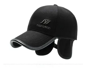Dettaglio cappello invernale in lana con paraorecchie e logo in metallo norason