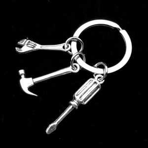 Detail of silver tool keychain with miniature hammer, wrench and screwdriver charms