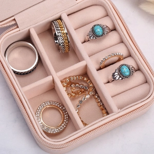 Pink portable travel jewelry box with square zipper and velvet interior storage slots