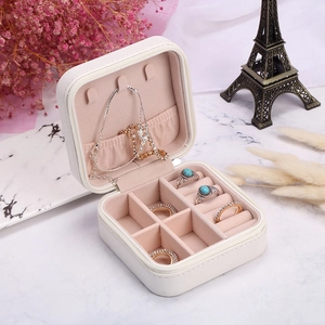 Portable white velvet jewelry box with necklace hooks and ring slots for travel storage