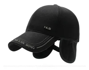 Detail of black winter baseball cap featuring folding ear flaps and metal logo