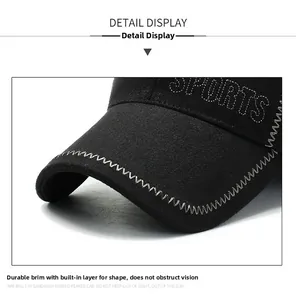 Detail view of reinforced peak on black winter sports cap with decorative silver stitching