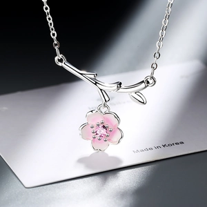Pink cherry blossom necklace pendant with silver branch and zircon in minimalist style
