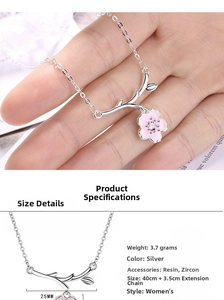Detail of pink cherry blossom necklace pendant with silver branch and zircon accents