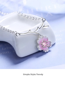 Macro detail of cherry blossom pendant with pink zircon and silver branch chain