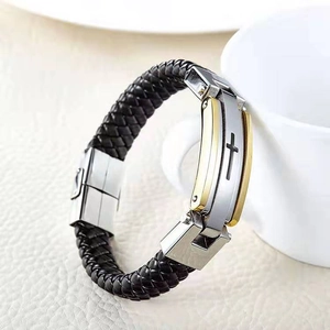 Dettaglio del bracciale da uomo in pelle intrecciata con fibbia a croce oro e argento