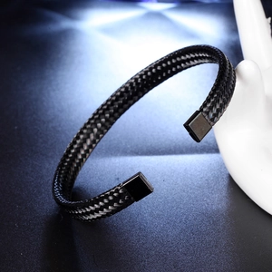 Black woven mesh C-shaped titanium steel bracelet with metallic clasp on white display stand