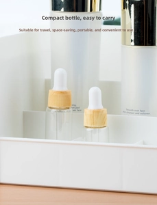 Macro shot of portable glass dropper bottles with light wood grain caps for skincare