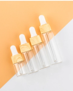 Detail of clear glass dropper bottles in four sizes with elegant wood grain caps