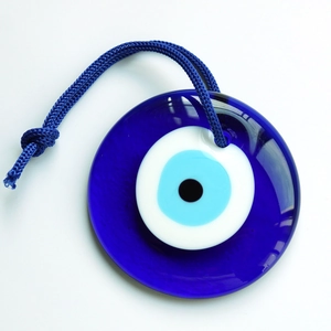 Détail du pendentif turc Evil Eye en verre bleu avec cordon tissé sur fond blanc