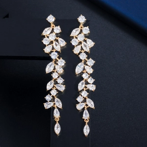 Detailed view of long gold drop earrings with petal-shaped zircon and tassel crystals