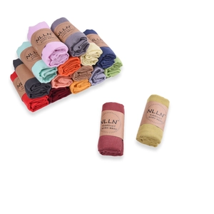 Macro detail of multicolored cotton linen kids' scarves with branded paper packaging