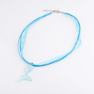 Detail of blue ribbon cord necklace with a transparent glittery mermaid tail pendant