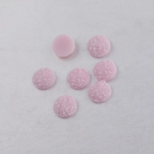 Macro detail of 10mm pink resin druzy cabochons with sparkling crystalline textures