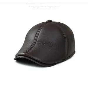 Détail de la casquette plate en cuir marron foncé montrant le grain et les coutures nettes