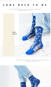 Detail of dark blue crew socks with white floral pattern paired with light denim jeans