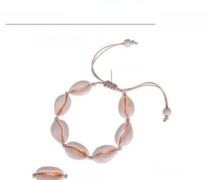 Detail of adjustable natural cowrie shell bracelet with woven rope and sizing specs