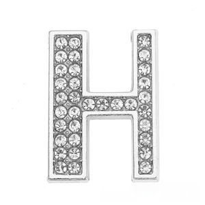 Macro detail of silver H-shaped charm with pavé crystals for DIY jewelry making