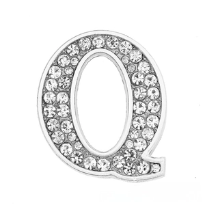 Macro shot of silver letter Q pendant with shimmering pavé crystal rhinestones for DIY jewelry