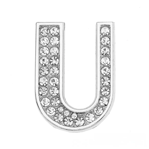 Close-up of silver-colored letter U charm accessory with clear crystal rhinestones