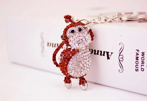 Macro view of crystal encrusted monkey keychain with orange and silver rhinestones