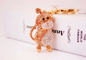 Detailed view of monkey keychain with sparkling orange and clear rhinestones on white book