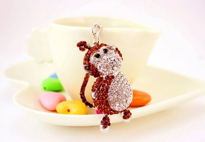 Detailed close-up of crystal monkey keychain with brown rhinestones and metal finish