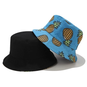 Détail montrant un bob noir classique et un chapeau bleu ciel avec motif d'ananas jaune