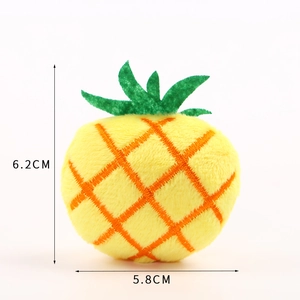 Detail of plush pineapple accessory with embroidery, measuring 6.2cm high by 5.8cm wide