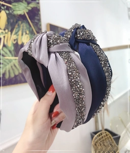 Detail of grey and navy knotted headbands with sparkling rhinestones on satin fabric