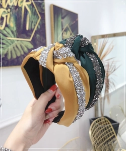 Close-up of knotted wide headbands in yellow and green with sparkling rhinestone crystals