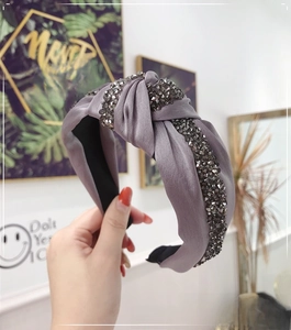 Detail of grey satin knotted headband with shiny dark grey rhinestones and sparkling finish