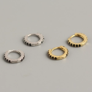 Detailed view of gold and silver 925 sterling silver hoop earrings with black zircon stones