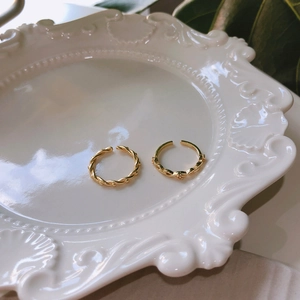 Detail of two adjustable 925 sterling silver gold rings on a ceramic jewelry tray