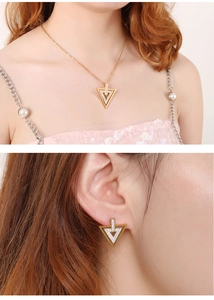 Détails d'un ensemble de bijoux géométriques dorés avec strass portés par un mannequin