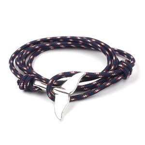 Close-up of navy blue and red braided bracelet with silver whale tail metal clasp