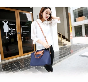 Navy nylon Boston bag with leather handles shown in a street lifestyle setting