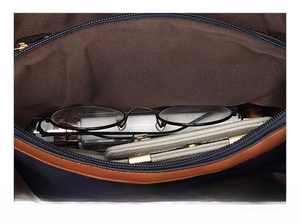 Interior view of navy oxford handbag showing storage for glasses and wallet