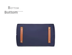 Detail view of navy nylon handbag bottom with brown leather strips and gold metal studs