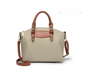 Front view of apricot Oxford cloth handbag with brown leather straps and gold hardware
