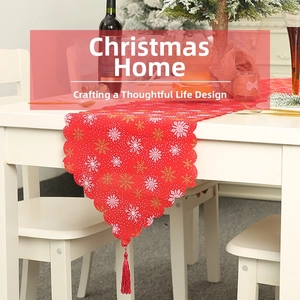 Detail eines roten Weihnachts-Tischläufers mit Schneeflocken und dekorativen Quasten