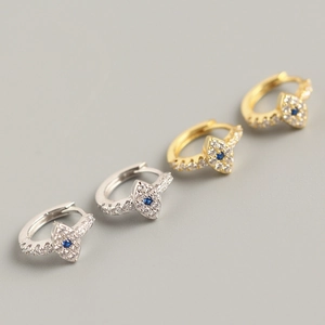 Detailed macro view of S925 sterling silver and gold evil eye hoop earrings with zircon