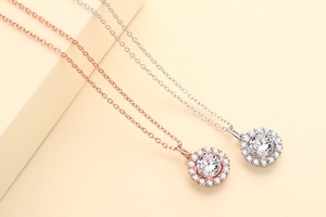 Detail of halo pendant necklaces in rose gold and silver finish with round white zircon