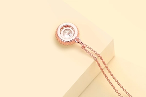 Detailed macro shot of rose gold geometric pendant with sparkling clear zircon gemstone