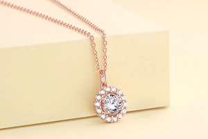 Macro shot of rose gold halo pendant necklace with a large round white zircon stone