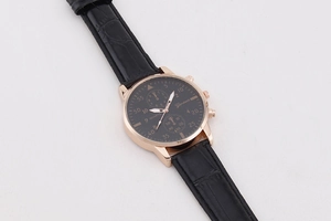 Detail der roségoldenen Uhr mit schwarzem Lederarmband und strukturiertem Zifferblatt